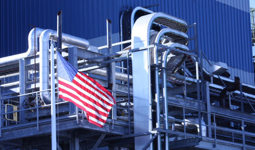 american flag in front of industrial factory building